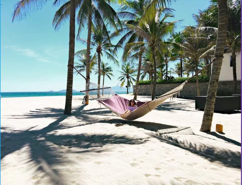 A hammock between coconut palms on Hà My Beach